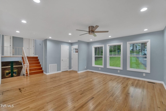 empty room with a wealth of natural light, ceiling fan, and light wood-type flooring