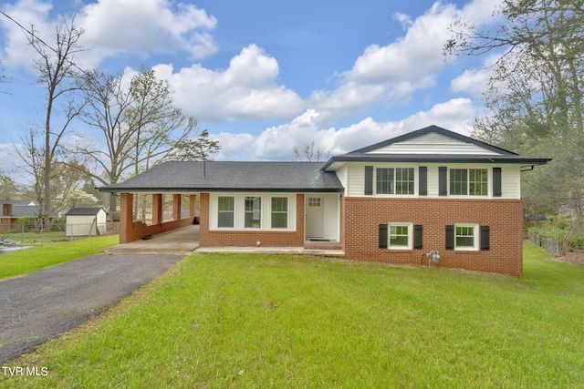 split level home with a front lawn and an outdoor structure