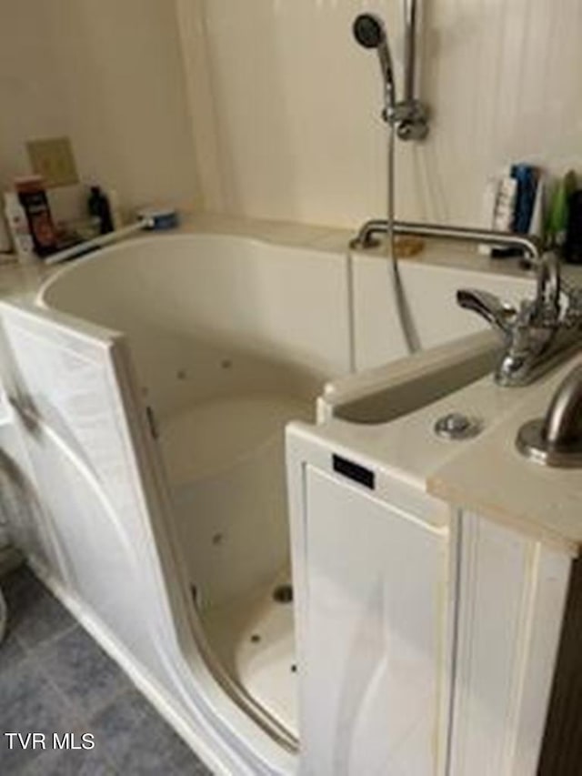 laundry room featuring dark tile flooring