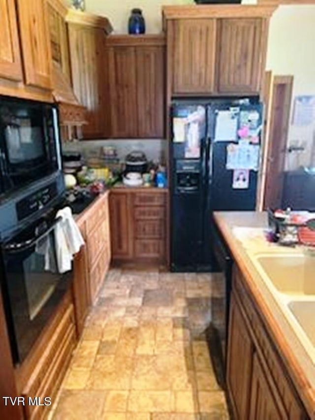 kitchen with light tile flooring and black appliances