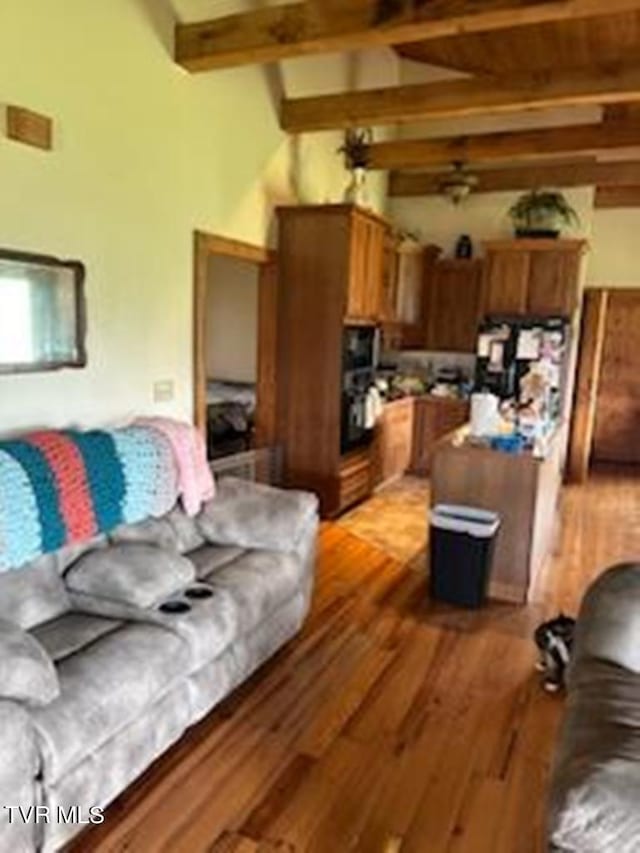 living room featuring wood-type flooring and beam ceiling