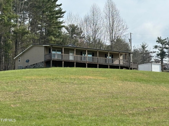 rear view of property featuring a deck and a yard