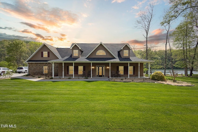 view of front of property with covered porch and a lawn