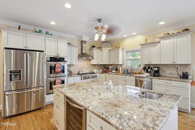 kitchen featuring beverage cooler, wall chimney range hood, stainless steel appliances, a kitchen island, and tasteful backsplash