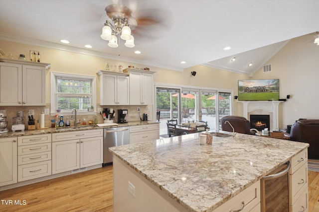 kitchen with crown molding, sink, light stone counters, tasteful backsplash, and dishwasher