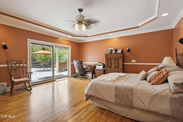 bedroom with light hardwood / wood-style floors, ceiling fan, access to exterior, and a tray ceiling