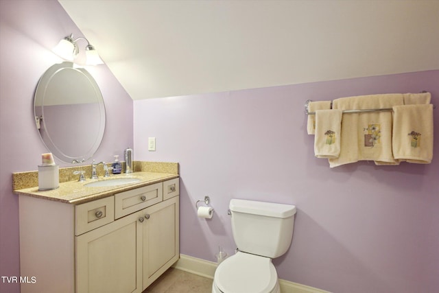 bathroom featuring vanity, vaulted ceiling, tile floors, and toilet