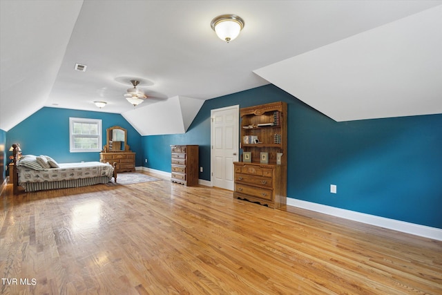 unfurnished bedroom with vaulted ceiling, ceiling fan, and light wood-type flooring