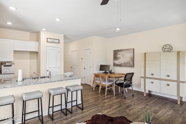 115 Raceday Center Dr Unit D-3, Bristol, TN 37620 - kitchen featuring a kitchen bar, sink, white cabinetry, light stone counters, and dark hardwood / wood-style flooring
