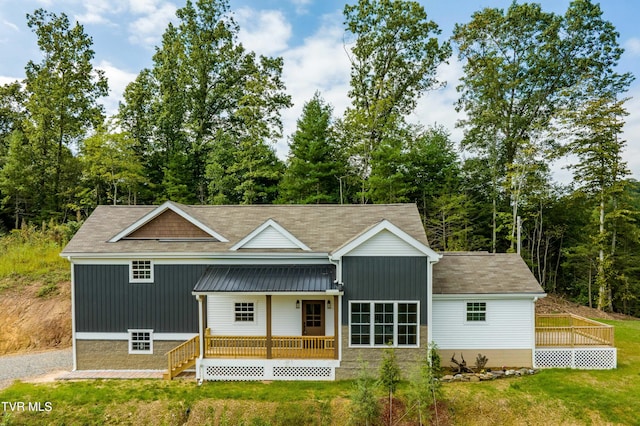 rear view of house featuring a porch and a yard