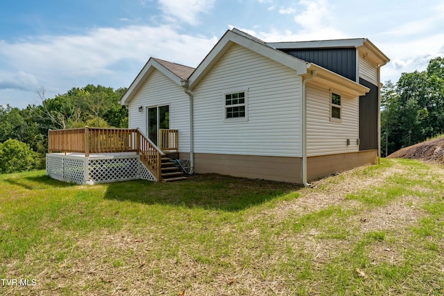 back of property with a yard and a deck