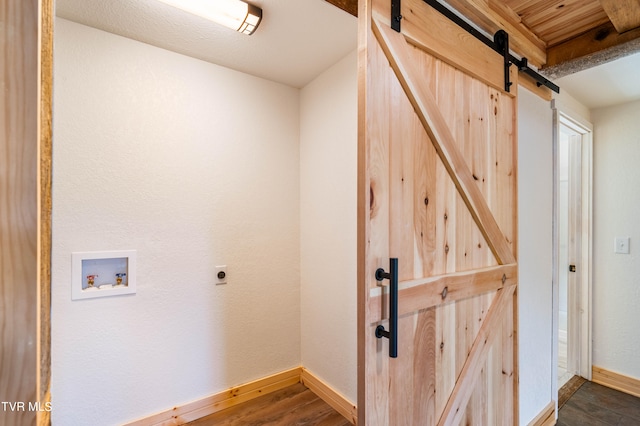 laundry room featuring hookup for a washing machine, a barn door, hookup for an electric dryer, wooden ceiling, and wood-type flooring