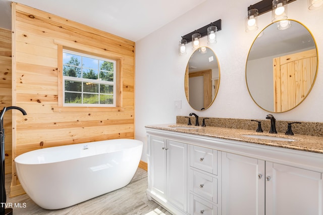 bathroom with wood walls, a bath, and dual bowl vanity