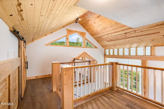 corridor featuring a barn door, wood-type flooring, lofted ceiling, and wood ceiling