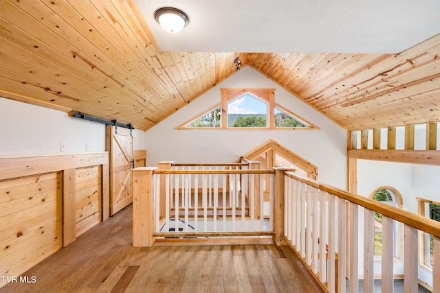 interior space featuring lofted ceiling, wood ceiling, hardwood / wood-style floors, and a barn door