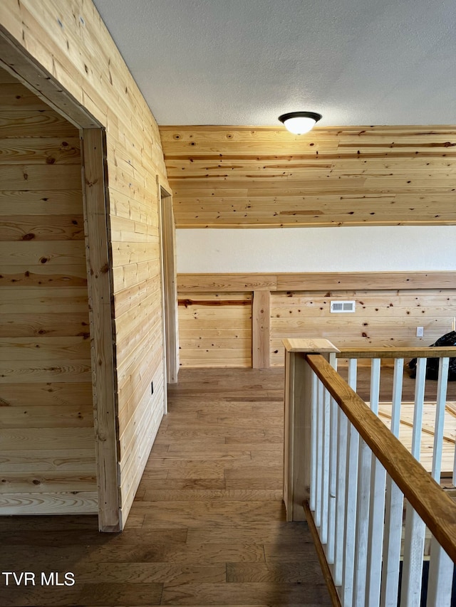 hallway with wood-type flooring and a textured ceiling