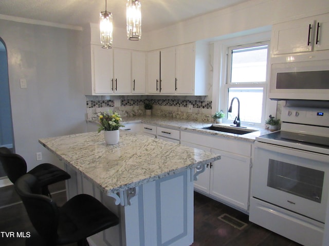 kitchen with a kitchen island, sink, white appliances, backsplash, and white cabinetry