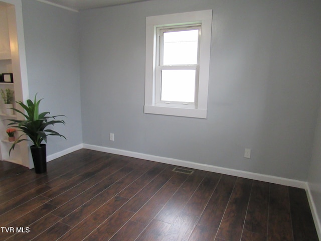 spare room with plenty of natural light and dark hardwood / wood-style floors