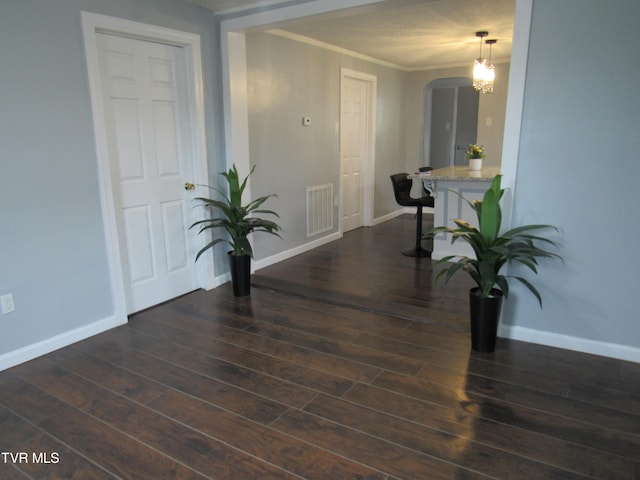 empty room with dark wood-type flooring and crown molding