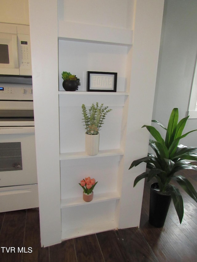 room details with dark hardwood / wood-style flooring and white appliances