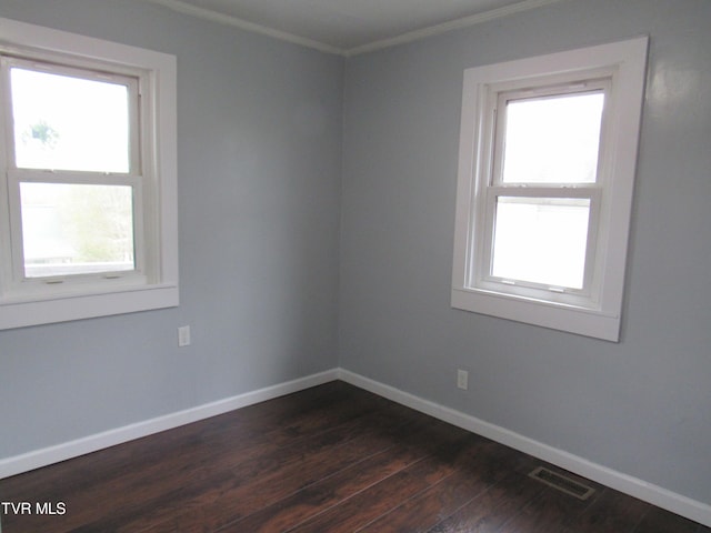 empty room featuring hardwood / wood-style flooring and ornamental molding