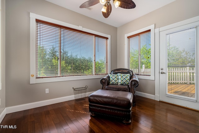 living area featuring ceiling fan, hardwood / wood-style flooring, and baseboards