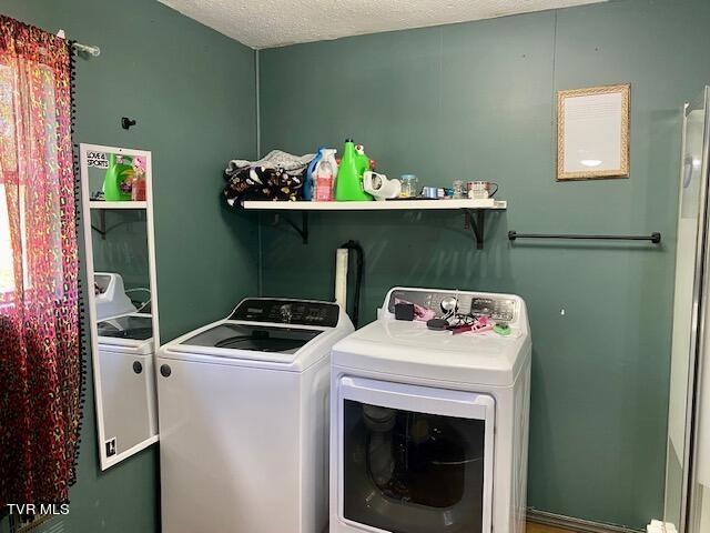 laundry area featuring washer and clothes dryer and a textured ceiling