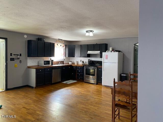 kitchen with hardwood / wood-style floors, sink, appliances with stainless steel finishes, and a textured ceiling