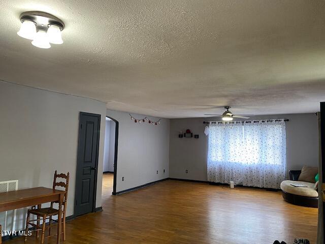 spare room with wood-type flooring, ceiling fan, and a textured ceiling