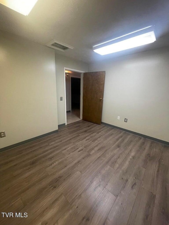 empty room featuring dark wood-type flooring