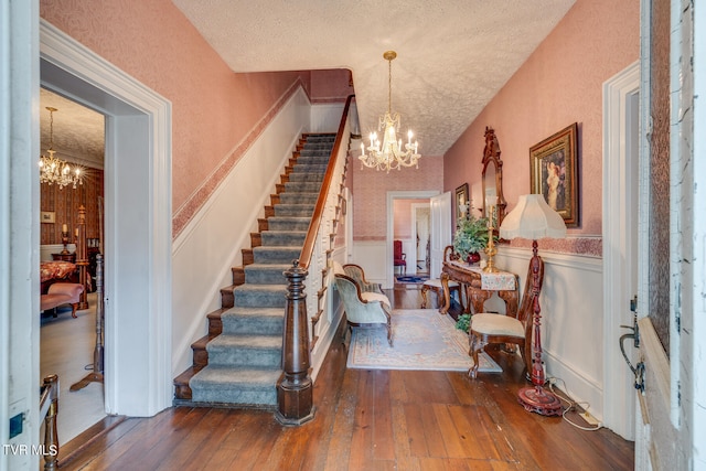 interior space with a textured ceiling, a notable chandelier, and hardwood / wood-style flooring