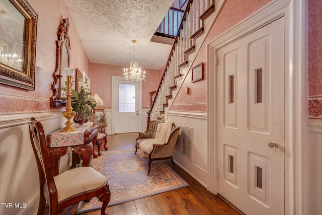 interior space with hardwood / wood-style floors, a chandelier, and a textured ceiling