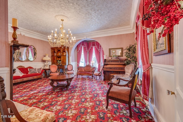 living room with ornamental molding, an inviting chandelier, carpet, and a textured ceiling