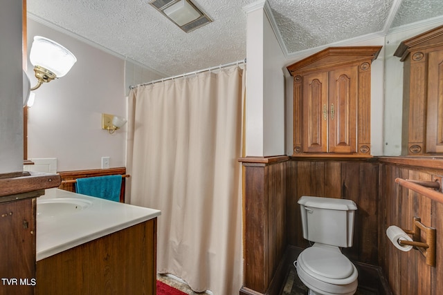 bathroom featuring ornamental molding, toilet, vanity, and a textured ceiling