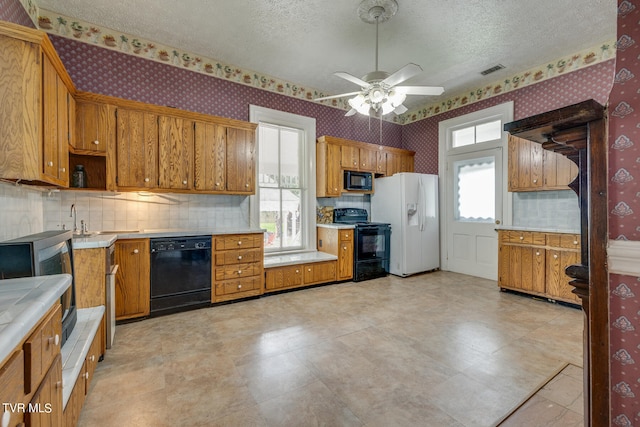 kitchen with ceiling fan, light tile flooring, black appliances, a textured ceiling, and tasteful backsplash