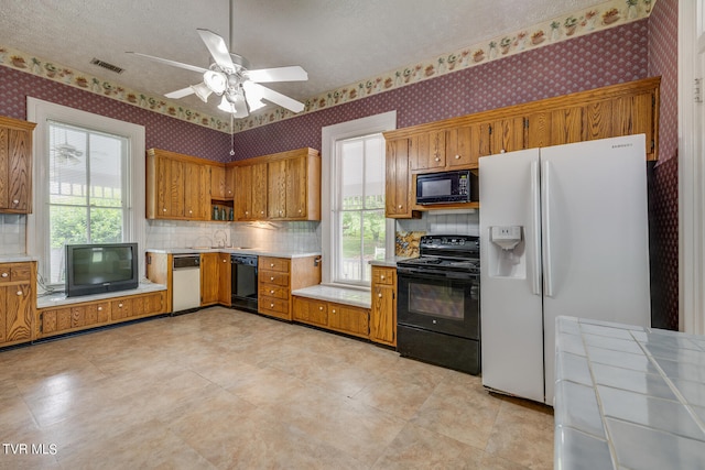 kitchen with tile counters, ceiling fan, black appliances, tasteful backsplash, and light tile floors