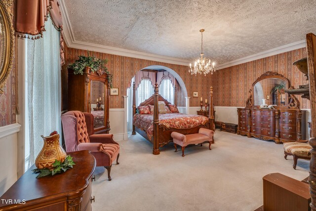 carpeted bedroom with ornamental molding, a notable chandelier, wooden walls, and a textured ceiling