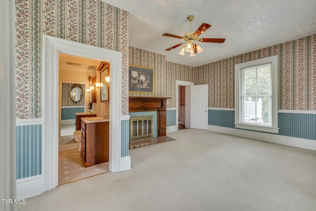 living room with a textured ceiling, ceiling fan, and carpet flooring