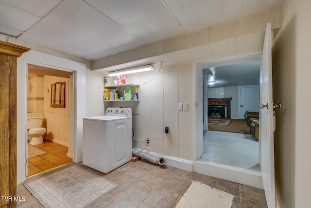 interior space with washer / dryer, toilet, and tile flooring