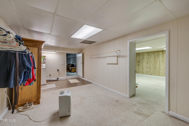 basement featuring a paneled ceiling and carpet floors