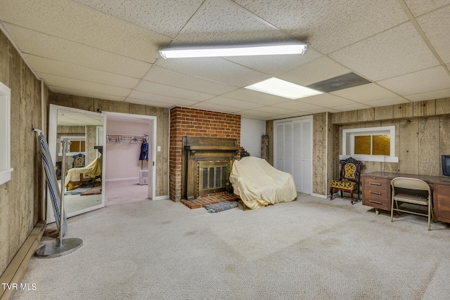 unfurnished bedroom with wooden walls and a drop ceiling