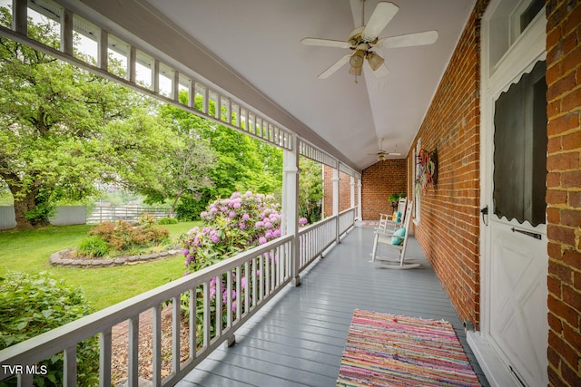 wooden deck featuring ceiling fan and a yard