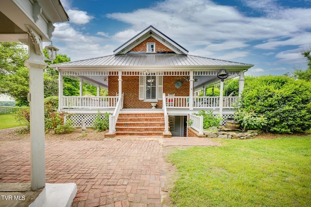 farmhouse featuring a front lawn and covered porch