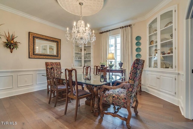 dining room with a chandelier, hardwood / wood-style flooring, and ornamental molding