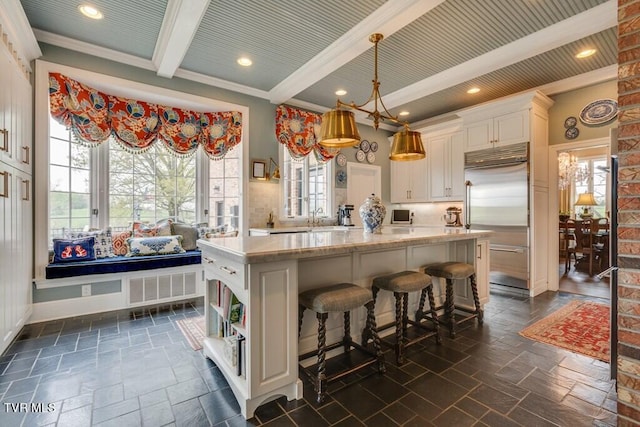 kitchen featuring beam ceiling, a center island, and plenty of natural light