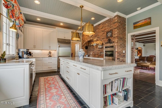 kitchen with beamed ceiling, dark tile patterned flooring, hanging light fixtures, and a kitchen island