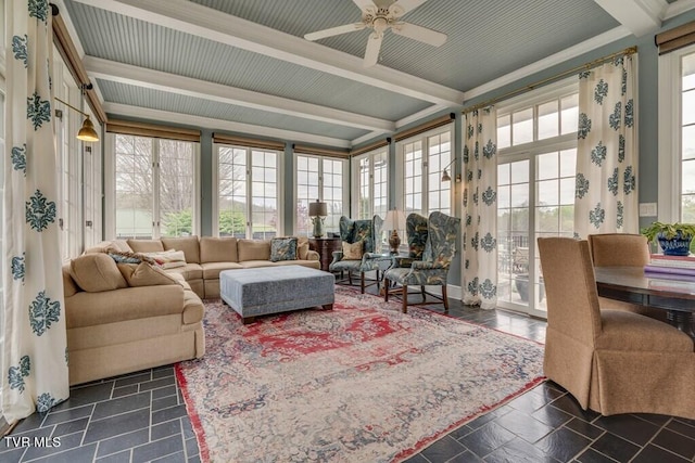 sunroom / solarium featuring beamed ceiling and ceiling fan