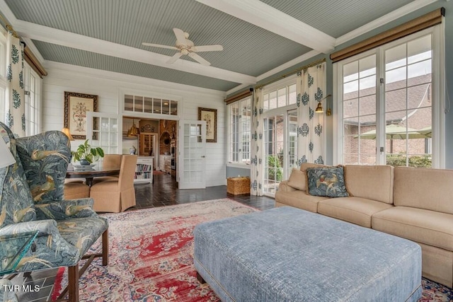 living room featuring a healthy amount of sunlight, beamed ceiling, and ceiling fan