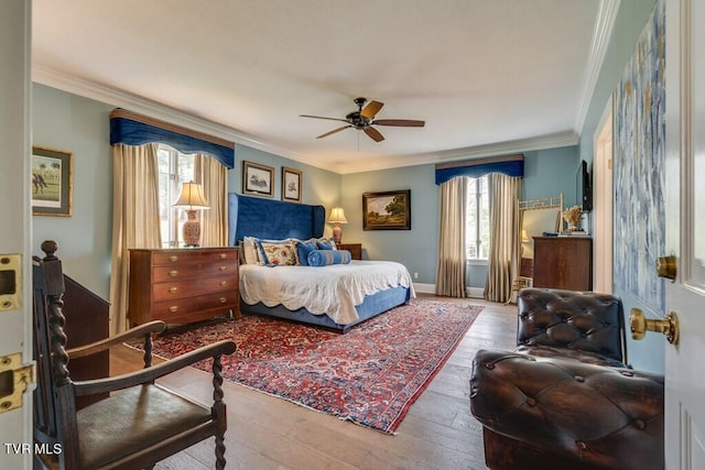 bedroom featuring wood-type flooring, ornamental molding, and ceiling fan