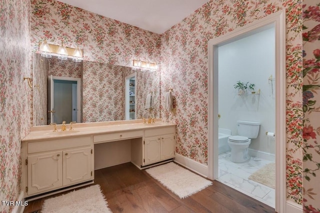 bathroom with toilet, wood-type flooring, and dual bowl vanity